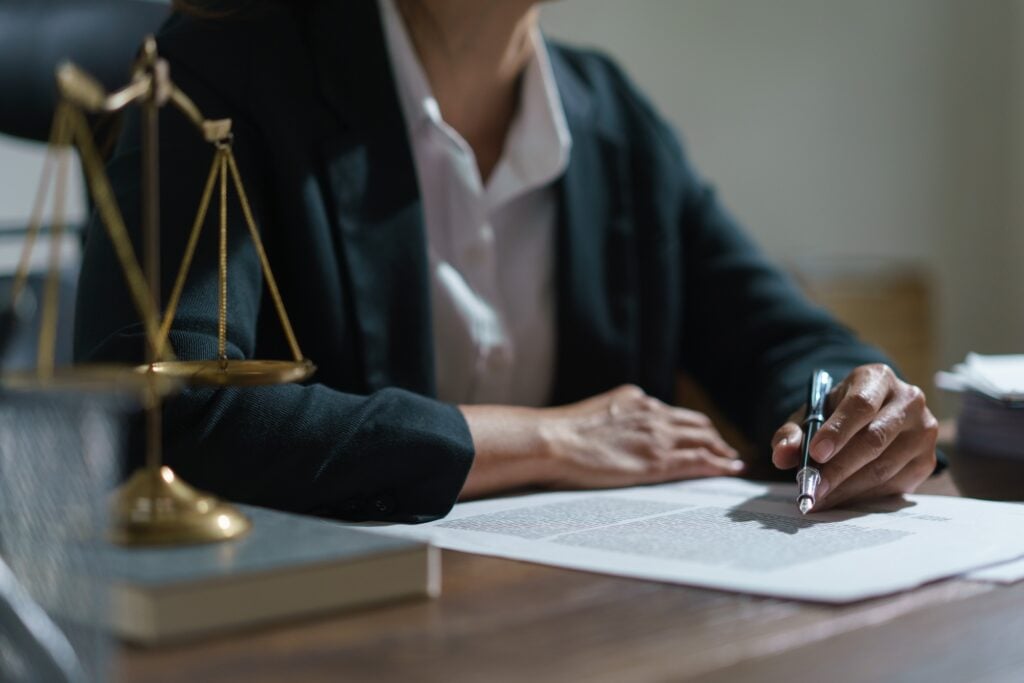 Businesswoman lawyer working and reading agreement business to signing on contract in legal office