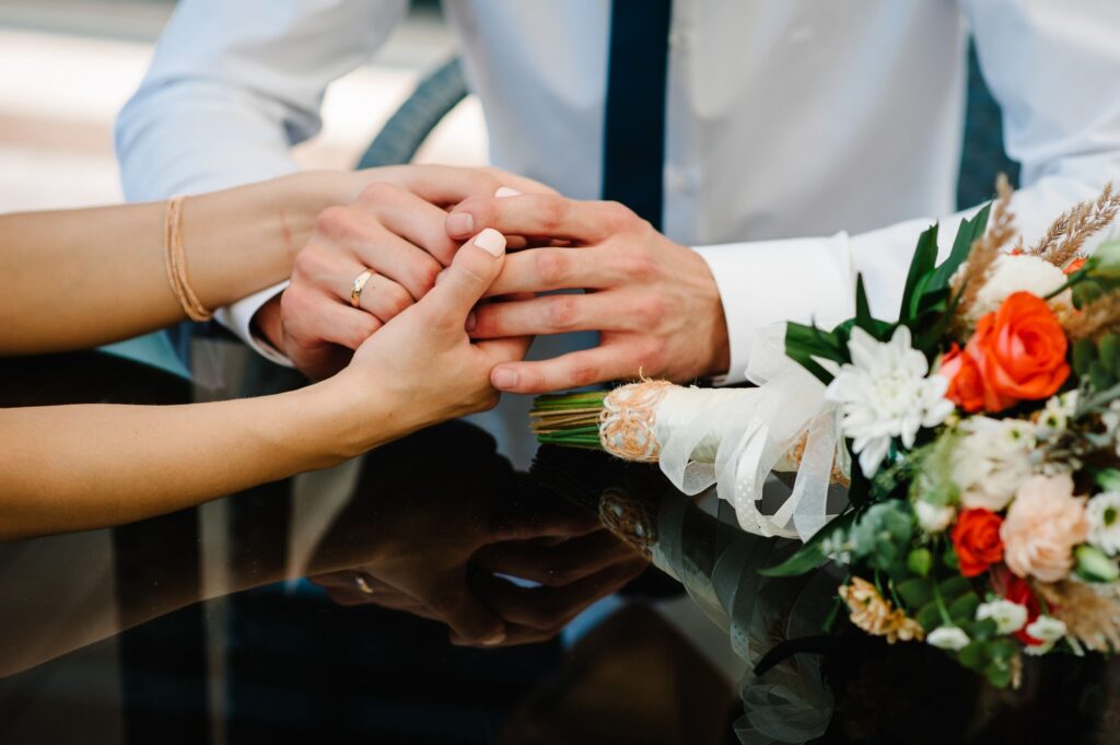 The Bride and groom holding hands with her bouquet.
